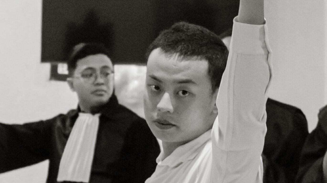 Tomy Priatna Wiria mengepalkan tangan kiri sebelum menjalani sidang pembacaan putusan sela di PN Denpasar, Selasa (07/04).