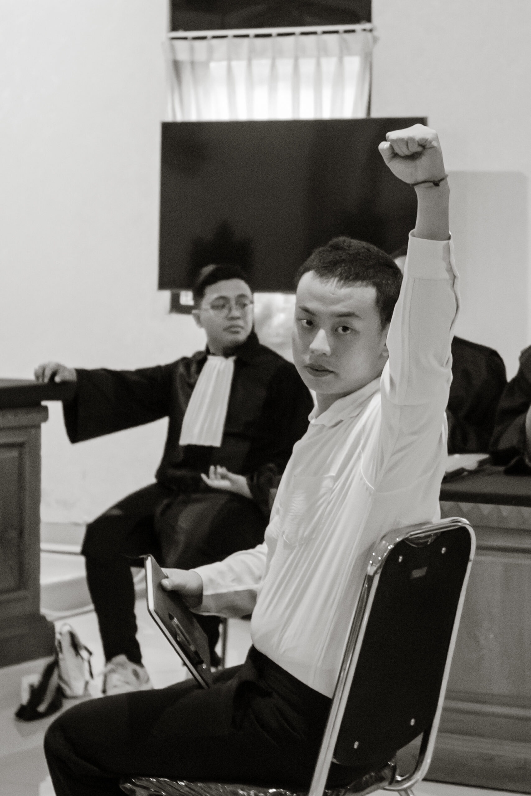 Tomy Priatna Wiria mengepalkan tangan kiri sebelum menjalani sidang pembacaan putusan sela di PN Denpasar, Selasa (07/04).